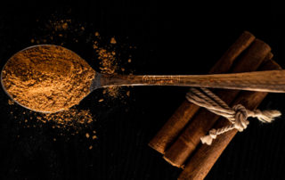 ground cinnamon on spoon dark background