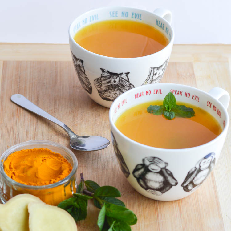 ginger turmeric tea in a white cup mint herbal